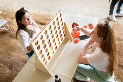 two women play a giant connect-four game
